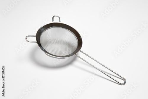 Metal sieve colander isolated on white background.Metallic strainer with handle. High resolution photo.Front side.