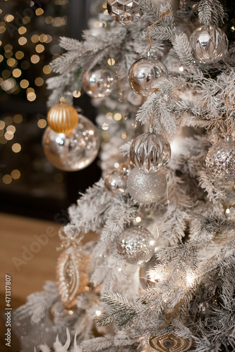 christmas tree decorations in silver and golden color palette with christmas lights. Silver shiny christmas tree.
