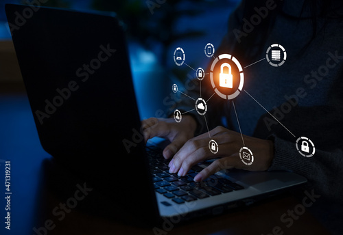 Fototapeta Naklejka Na Ścianę i Meble -  Business, technology, internet and networking concept. Young businesswoman working on his laptop in the office, select the icon security on the virtual display.