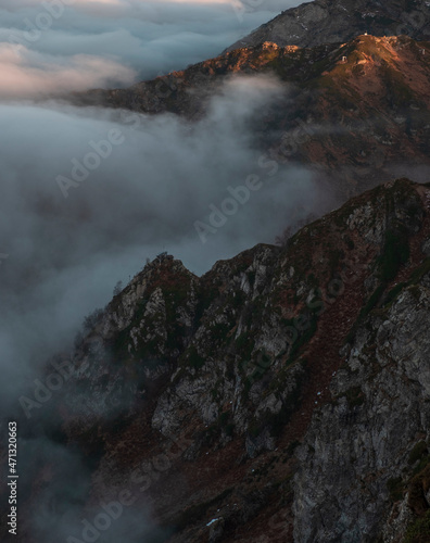 peak rocks in thick clouds at sunset in autumn