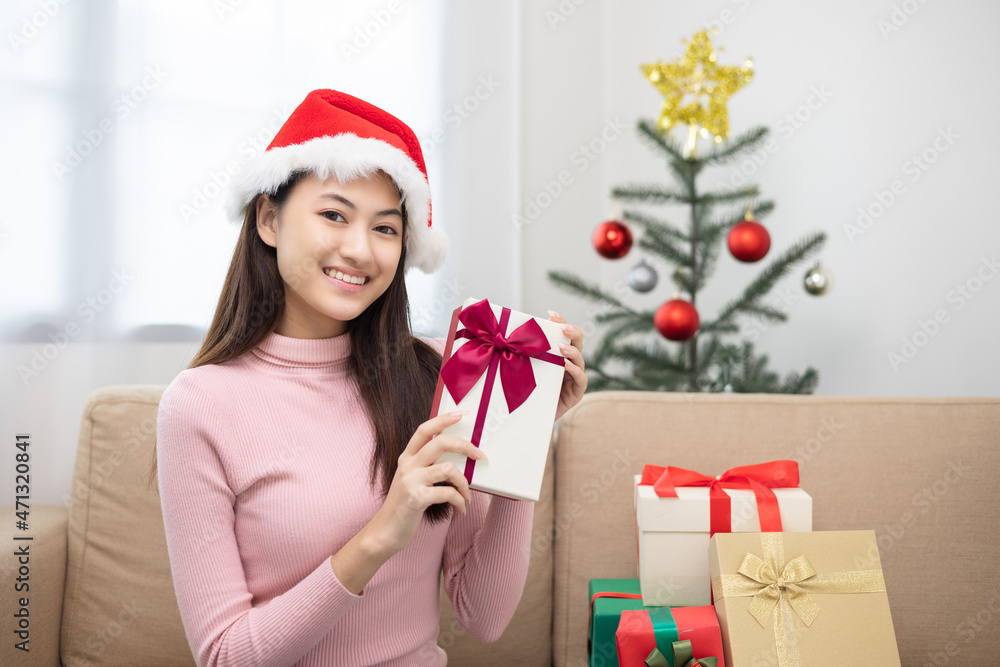 Happy beautiful Asian woman celebrate with present gift box in christmas party at home. Cute girl in christmas holiday holding gift box decorated with ribbon and bow. Happy new year festival. Happy beautiful Asian woman celebrate with present gift box in christmas party at home. Cute girl in christmas holiday holding gift box decorated with ribbon and bow. Happy new year festival.