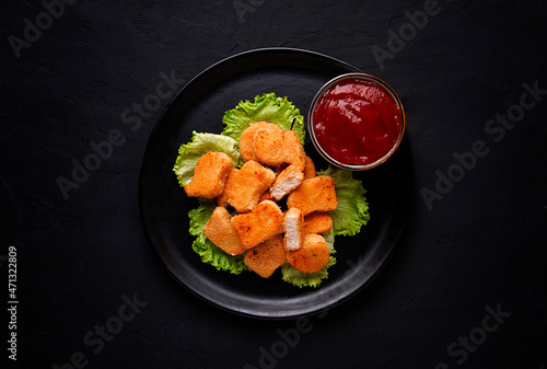 Fried chicken breast nuggets, on lettuce leaves, with tomato sauce, horizontal, no people, selective focus,