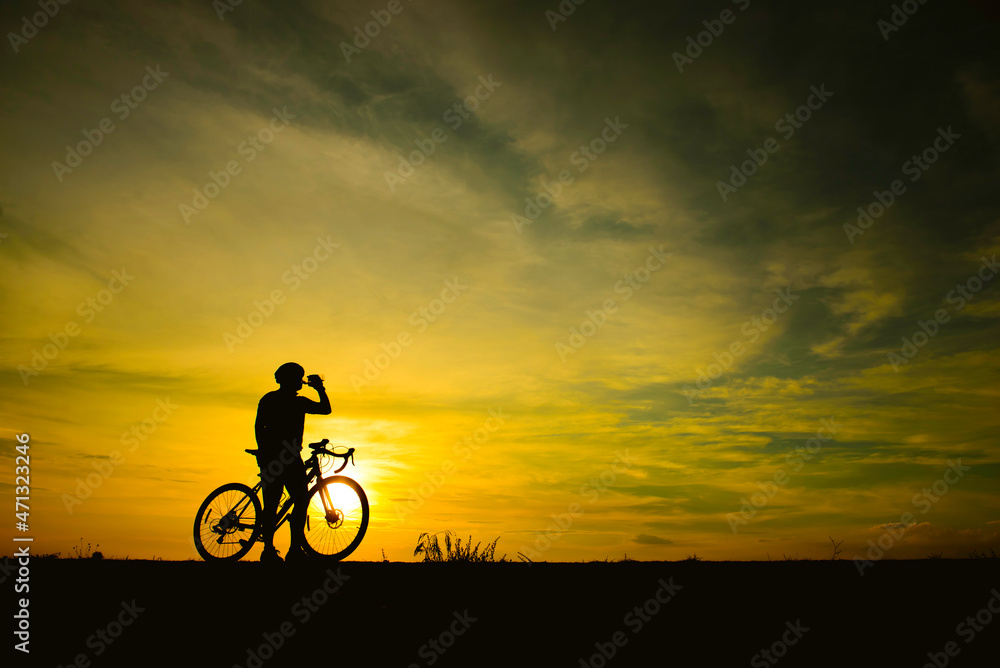 Silhouette of handsome man riding bicycle on sunset,sport man concept,Fill flare effect Silhouette of handsome man riding bicycle on sunset,sport man concept,Fill flare effect