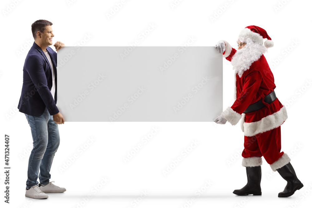 Full length profile shot of casual young man and santa claus carrying a blank panel Full length profile shot of casual young man and santa claus carrying a blank panel