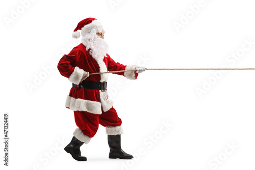 Full length profile shot of santa claus pulling a rope