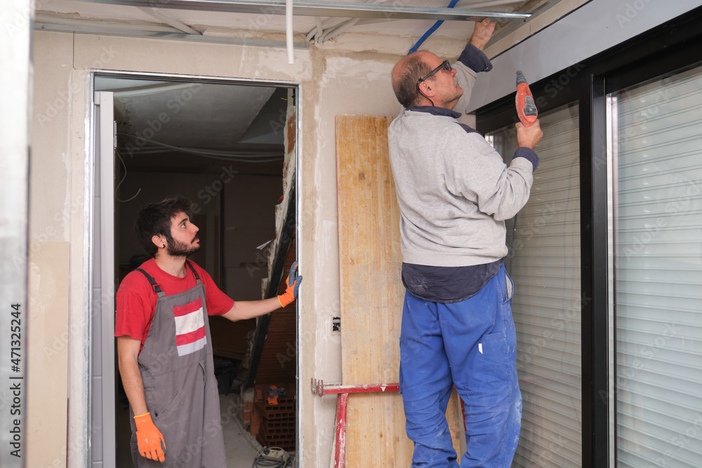 Contractor teaching how to assemble a suspended ceiling metal frame. Contractor teaching how to assemble a suspended ceiling metal frame.