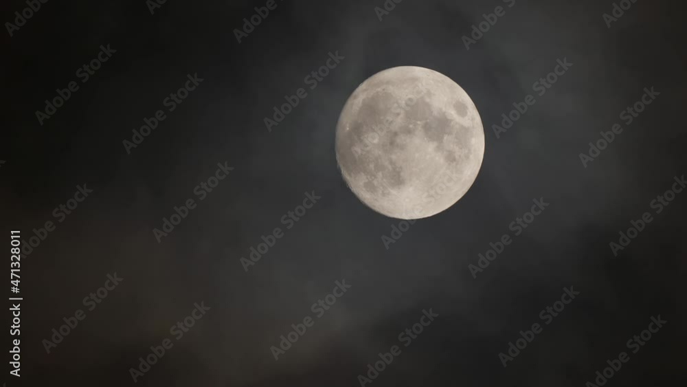 Eerie shot of a full moon through misty cloud on dark sky Eerie shot of a full moon through misty cloud on dark sky