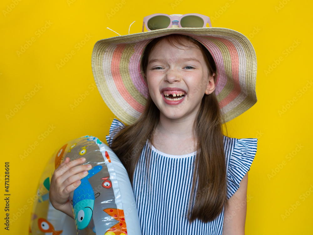 portrait of a little girl in sunglasses, hat, with a rubber ring