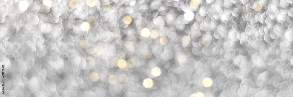 Obraz premium Silver and golden sparkling glitter bokeh background, christmas texture. Holiday lights. Abstract defocused header. Wide screen wallpaper. Panoramic web banner with copy space for design