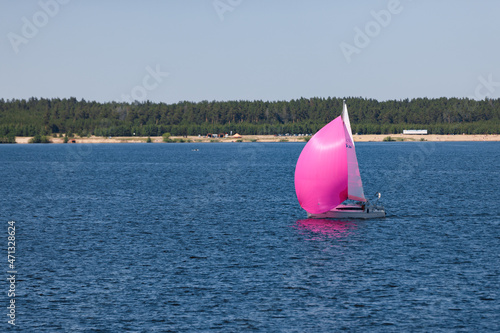 A boat with scarlet sails floats on the river