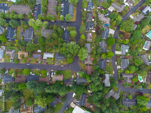 Shooting from a drone. Small green town. Roofs of small houses, lots of greenery, asphalt roads. Map, topography, planning, real estate, infrastructure, social and environmental issues.