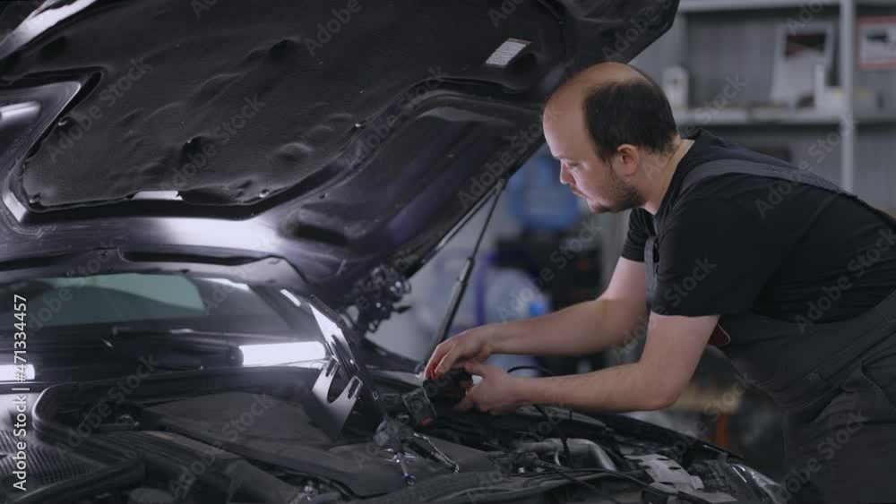 Using Digital Tablet For A Car Diagnostic. mechanic using a tablet pc at the repair service. Interactive Diagnostics Software on an Advanced Computer. Using Digital Tablet For A Car Diagnostic. mechanic using a tablet pc at the repair service. Interactive Diagnostics Software on an Advanced Computer.