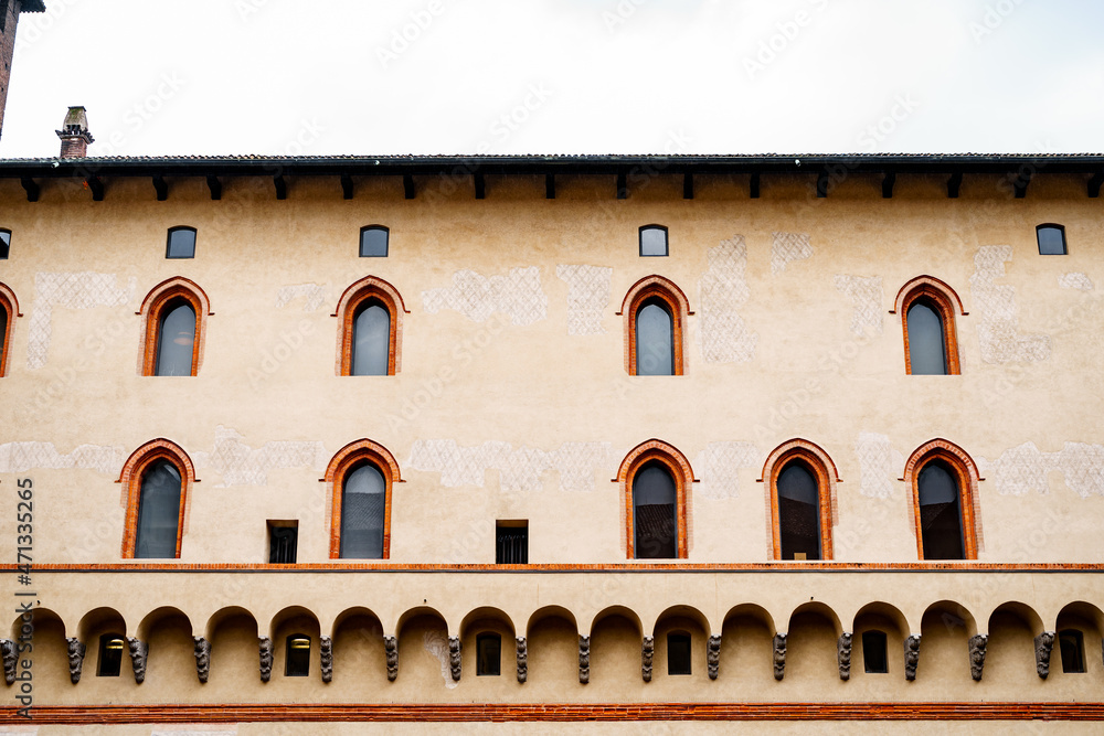 Arched windows and molding on the Castello Sforzesco wall. Milan, Italy