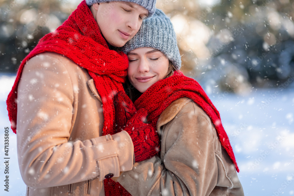 Closeup portrait of loving couple enjoying snowy winter day together