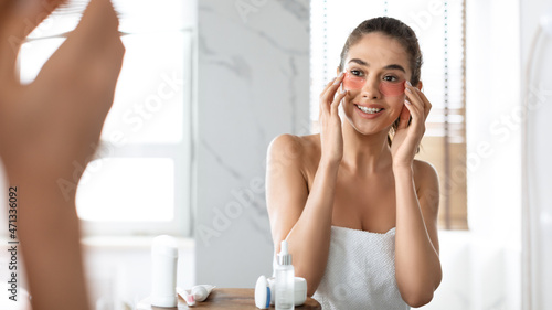 Attractive Lady Applying Patches Moisturizing Skin Under Eyes In Bathroom