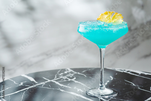 Blue Hawaiian Cocktail in glass summer drink concept. blue cocktail with pineapple on marble table