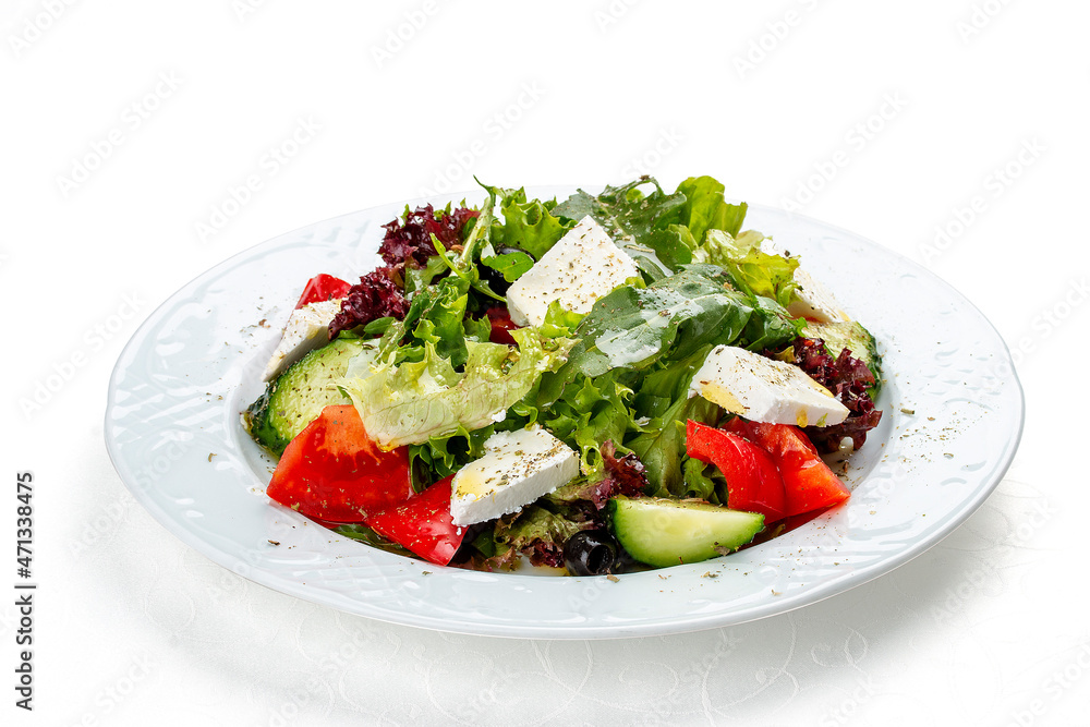 Greek salad with fresh vegetables and feta cheese. Isolated on a white background Greek salad with fresh vegetables and feta cheese. Isolated on a white background