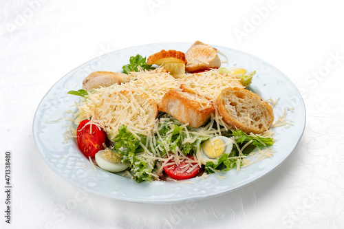 Caesar salad with chicken, egg and fresh vegetables. Isolated on a white background