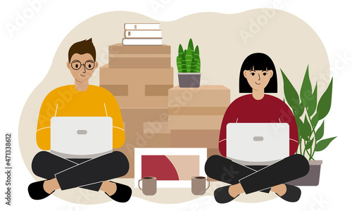 Couple sitting cross-legged with laptops, ordering delivery. Lots of things in cardboard boxes. The family is preparing to move to another house.