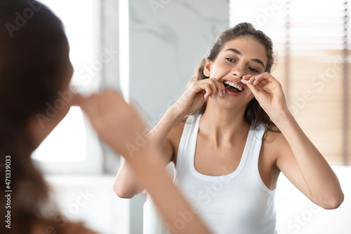Lady Using Floss Cleaning Teeth In The Morning In Bathroom