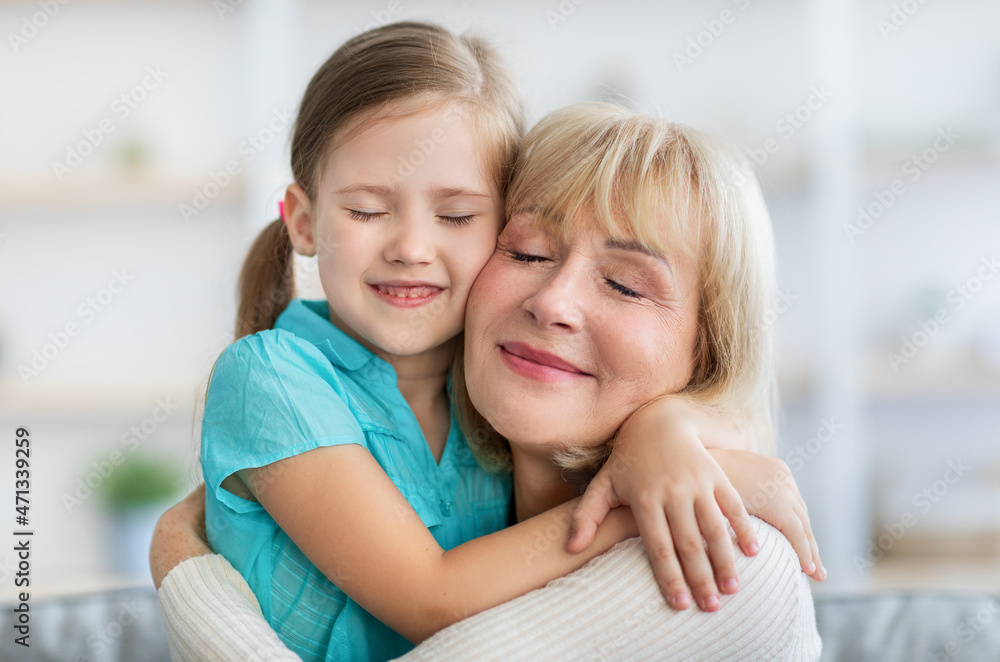 Happy mature woman and granddaughter hugging, closeup Happy mature woman and granddaughter hugging, closeup