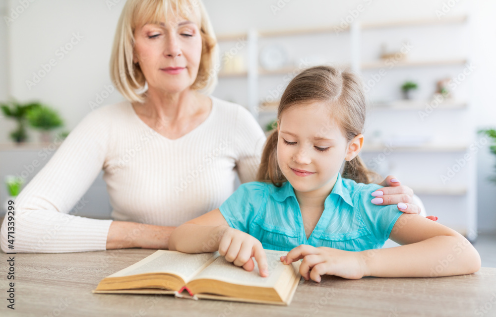 Portrait of mature woman and granddaughter reading book Portrait of mature woman and granddaughter reading book