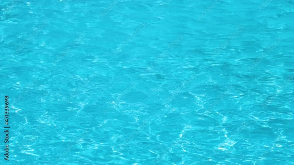 Closeup surface of blue clear water with small ripple waves in swimming pool Closeup surface of blue clear water with small ripple waves in swimming pool