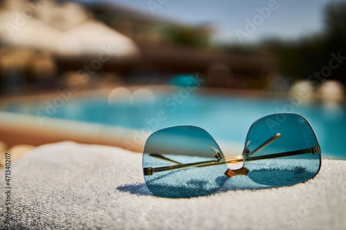 Beautiful sunglasses on the background of the pool. Relax by the pool. Sunglasses. 