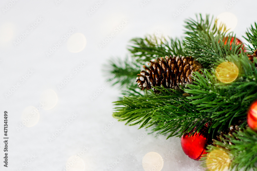 Decorated Christmas tree brunch on white background with lights, toys and cones. Natural decoration concept, copyspace