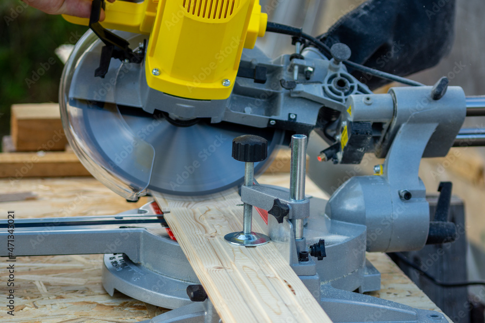 Sawing a board with a miter saw Sawing a board with a miter saw