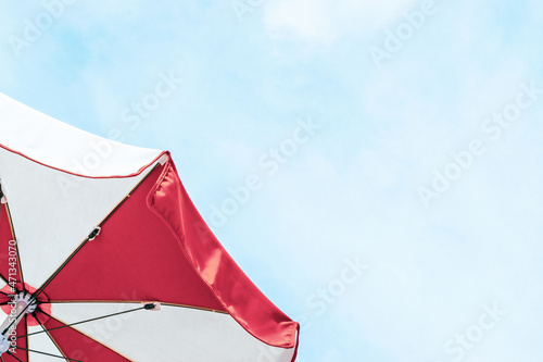 Umbrella beach. Red summer beach parasol on blue sea background. Sun sunshade for vacation travel. Outdoor relax holiday at ocean with copy space.