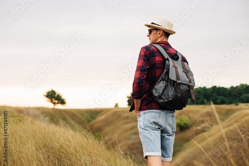 Hiker with a backpack enjoying the view of the valley, the tourist walks along the valley. Travel and adventure concept