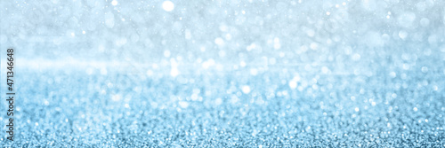 Blurred defocused bokeh banner with Christmas lights and silver glitter sparkles.