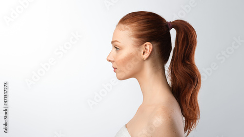 Side-view portrait of teenager girl on gray background, panorama photo