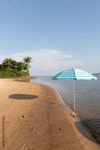 Vertical photo of a beach umbrella on the Xingu River, northern Brazil.