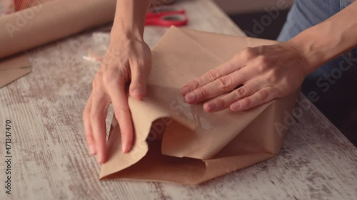Wallpaper Mural Young woman wrapping a gift, decorating stylish gift in craft paper on table in home Torontodigital.ca