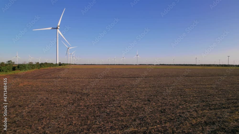 Windmills in a plowed field. Wind farm with turbine cables for wind energy. Renewable energy source, earth care. Drone video of wind power station, 4k. Botiyevska Ves, Ukraine. Windmills in a plowed field. Wind farm with turbine cables for wind energy. Renewable energy source, earth care. Drone video of wind power station, 4k. Botiyevska Ves, Ukraine.