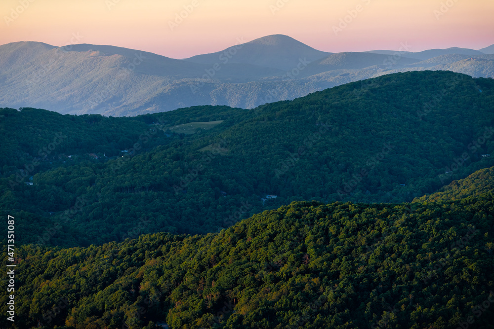 High angle view from Sugar Mountain of sunset dusk ridge layers and peaks in North Carolina Blue Ridge Appalachias with silhouette, trees and pastel color
