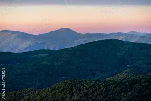 View from Sugar Mountain of sunset dusk ridge layers and peaks in North Carolina Blue Ridge Appalachias with silhouette, trees and pastel color