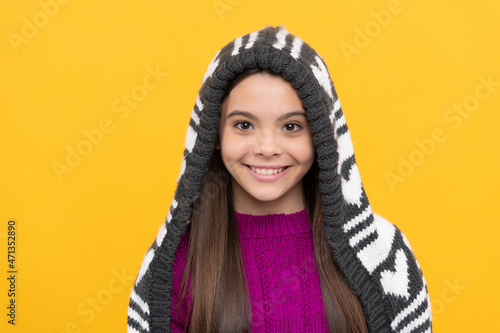 happy kid in earflap hat on yellow background, winter © Olena