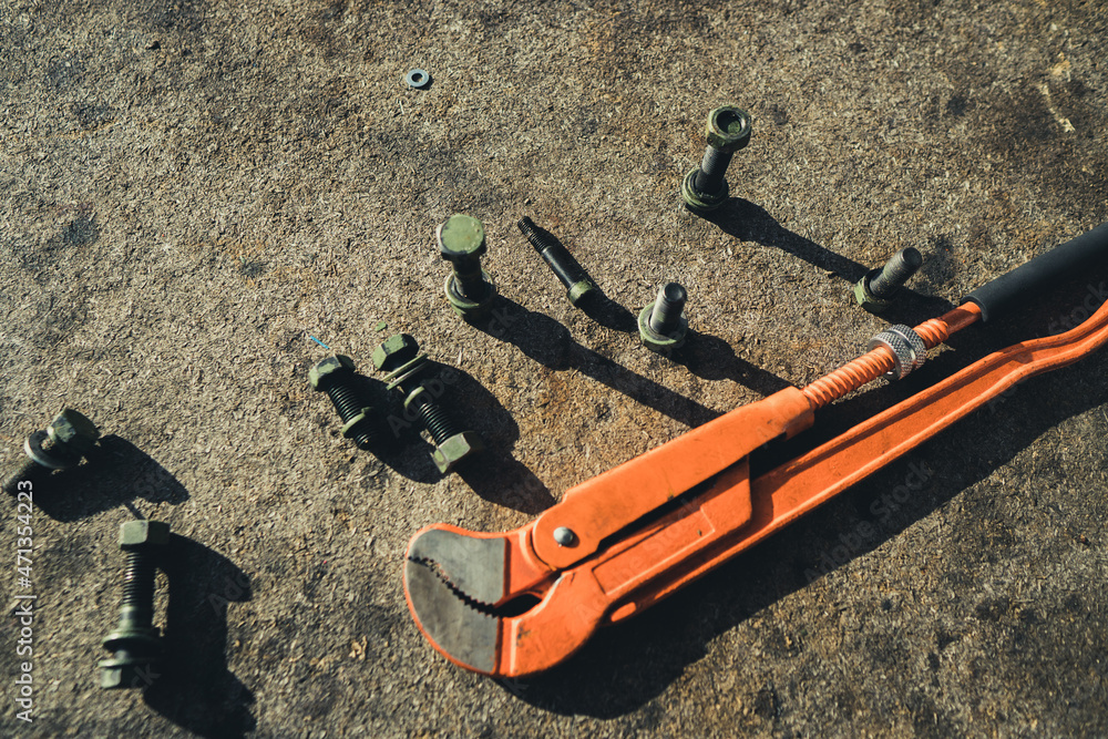 Screws, bolts and fasteners, wrench on an industrial background.