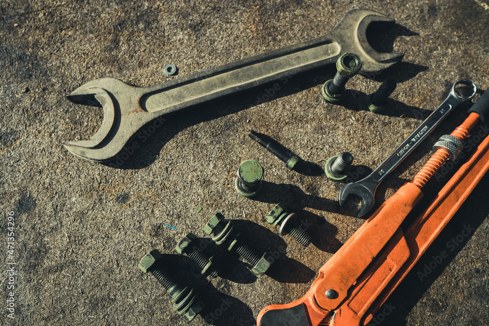 Screws, bolts and fasteners, wrench on an industrial background.
