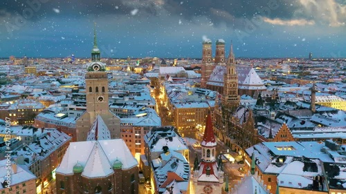 Munich skyline aerial drone video at winter snow falling munich marienplatz sqaure franuenkirche church , cathedral birds vew, munich winter city germany.