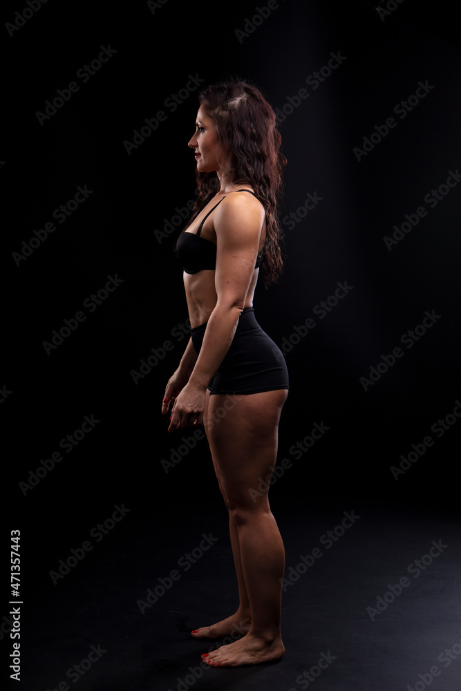Portrait of beautiful athletic woman with long curly black hair. Bodybuilding