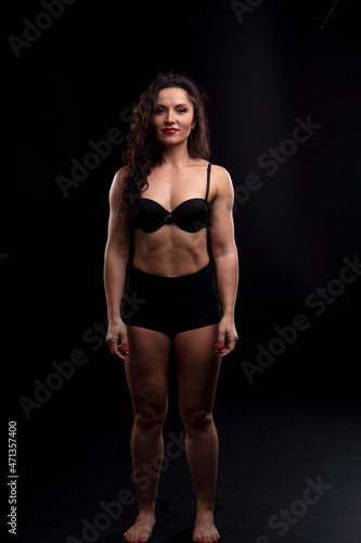 Portrait of beautiful athletic woman with long curly black hair. Bodybuilding