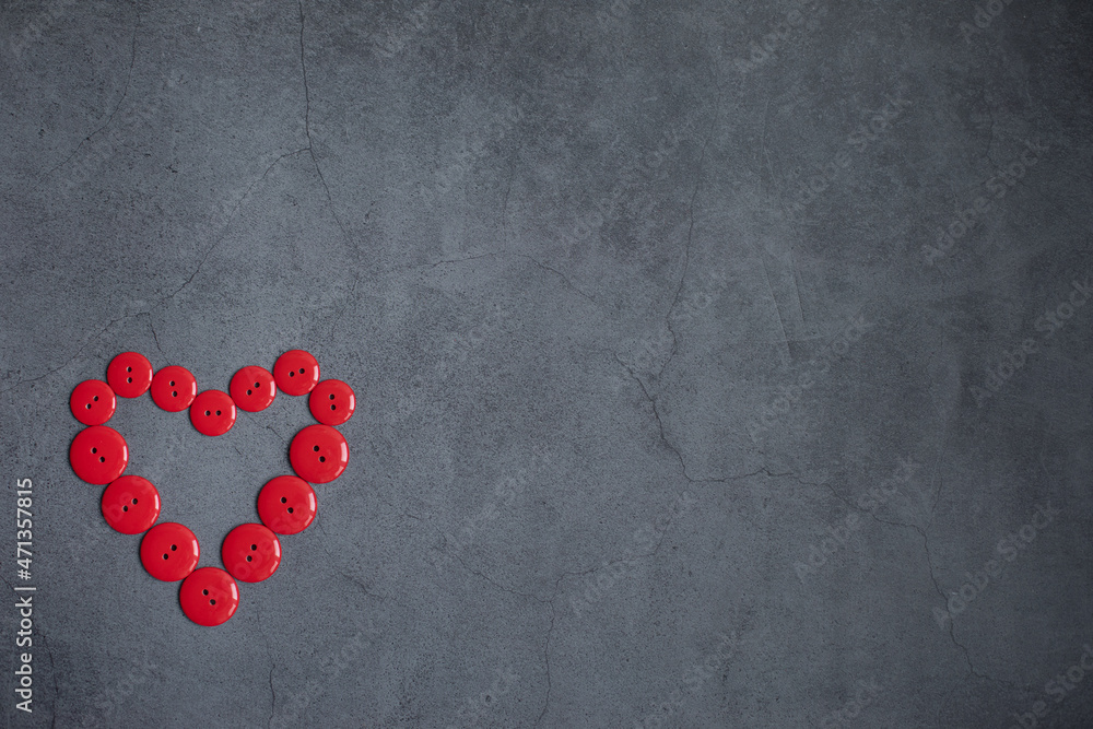 Obraz premium Heart is composed of red buttons on a dark gray background. Accessories for needlework. Concept Valentines Day.