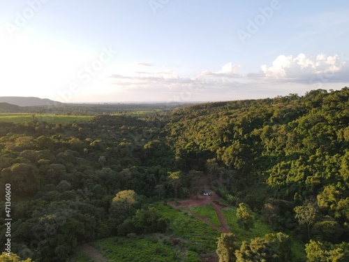  aerial photo of dense forest and abandoned house below