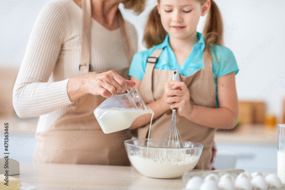 Lady and her granddaughter kneading dough, closeup Lady and her granddaughter kneading dough, closeup