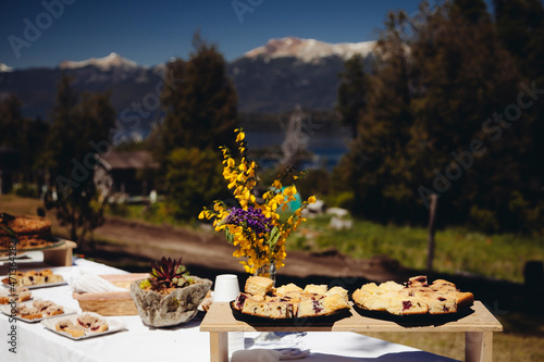 mesa con mantel blanco y cielo azul en las monta  as y flores