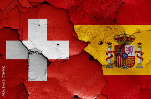 flags of Switzerland and Spain painted on cracked wall
